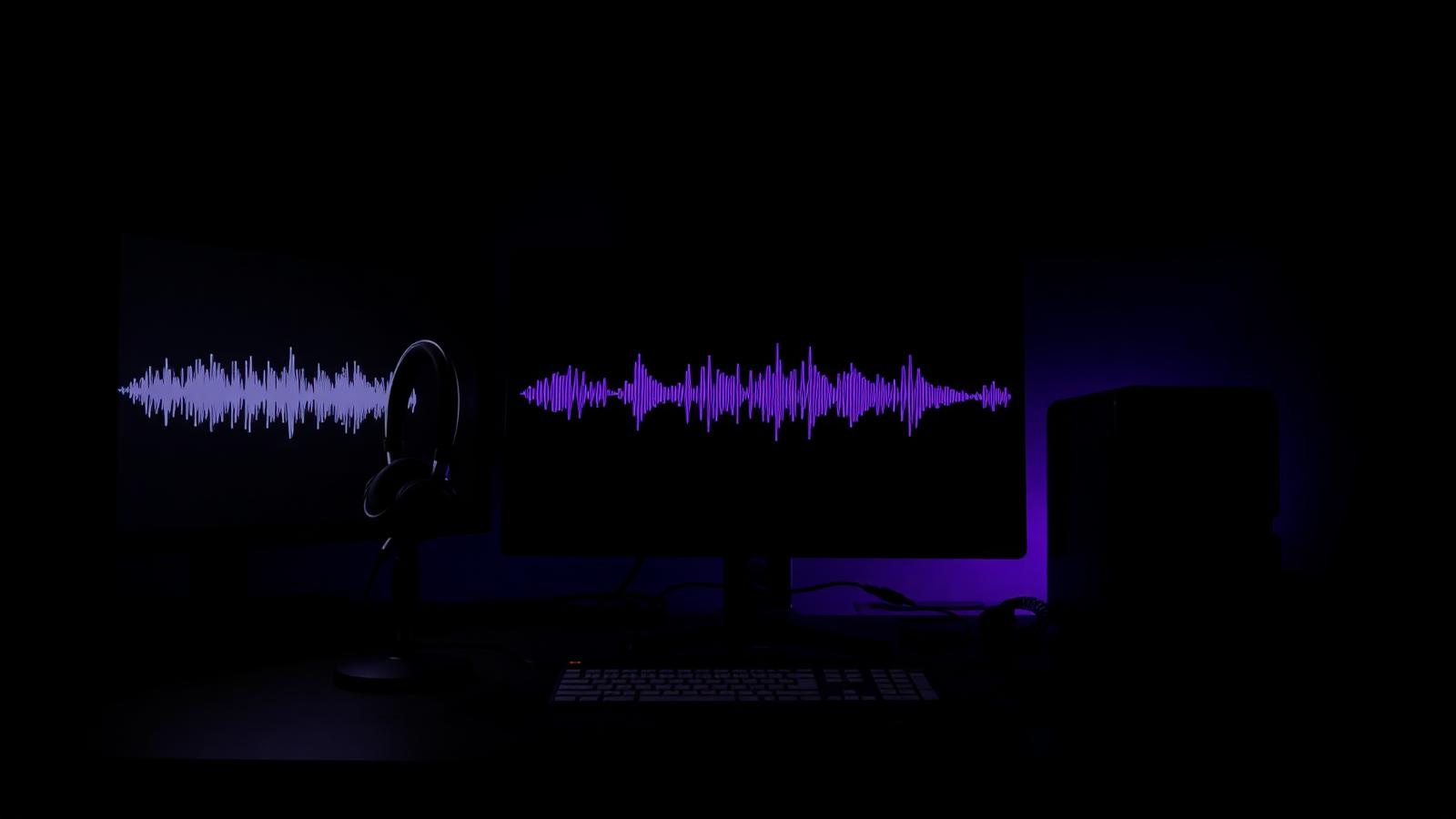 Dark editing workstation with waveform visible on the monitor